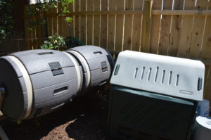A Picture of a rectangular compost bin and a double barrel type of composter.